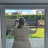 Une personne qui ferme la moustiquaire de fenêtre
